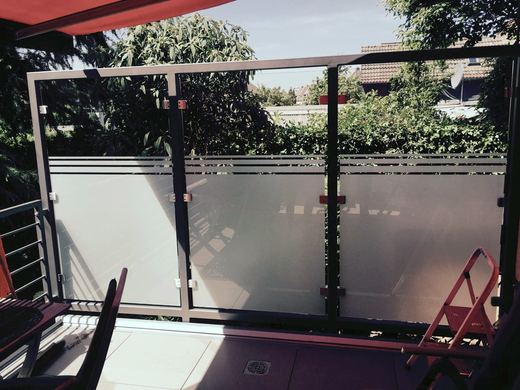Windschutz mit teilsatiniertem Glas auf einem Balkon