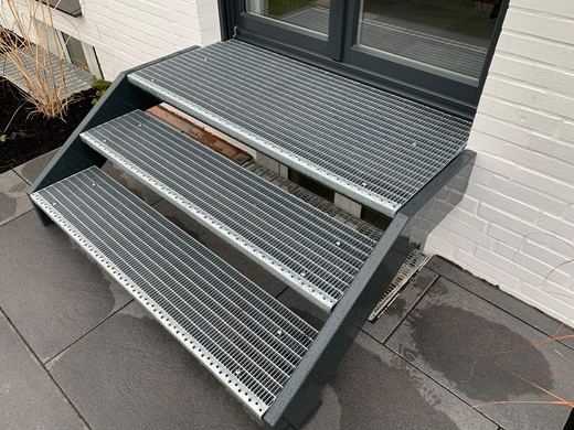 Stahltreppe mit verzinkten Gitterroststufen und anthrazitfarbenen Wangen
