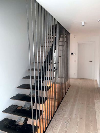Innentreppe mit raumhoher Stabwand aus Stahl
