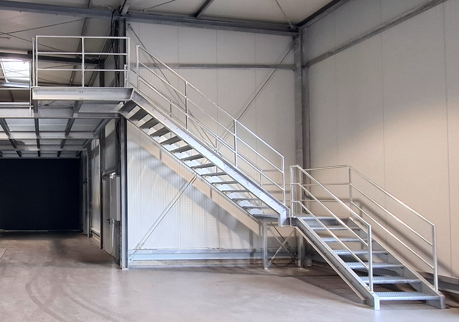 Stahlbühne mit zweiläufiger Treppe in einer Industriehalle