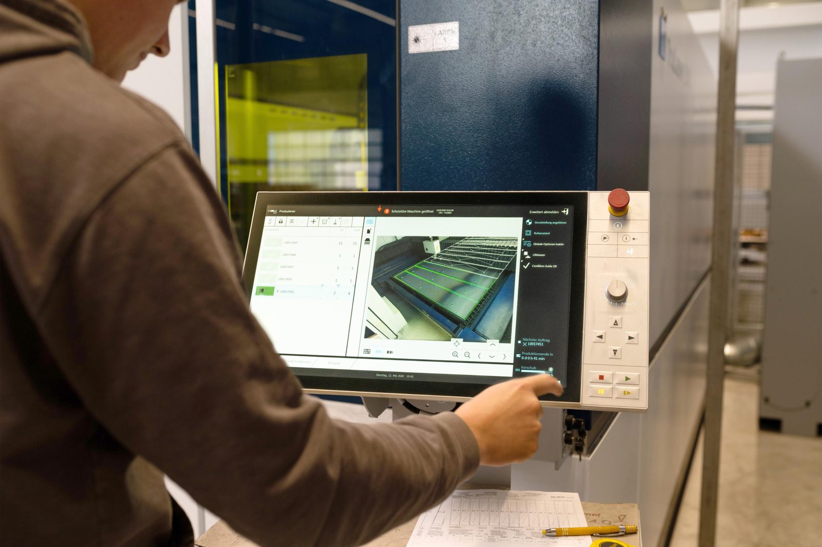 Mitarbeiter bedient die Laseranlage am Touchscreen